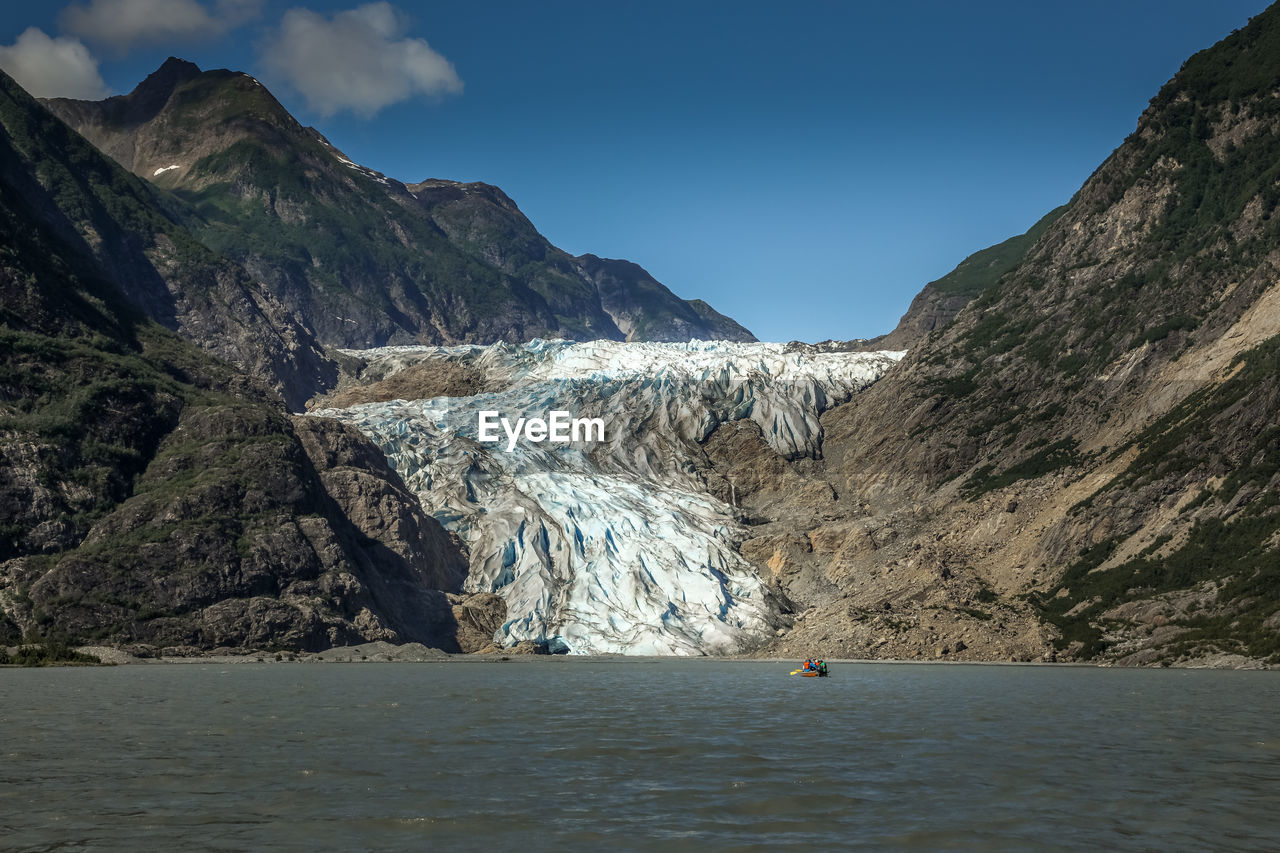 Scenic view of glacier and mountains against sky