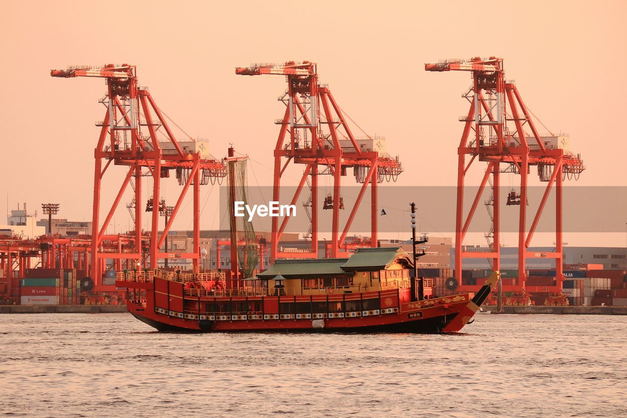 Side view of boats in river against clear sky