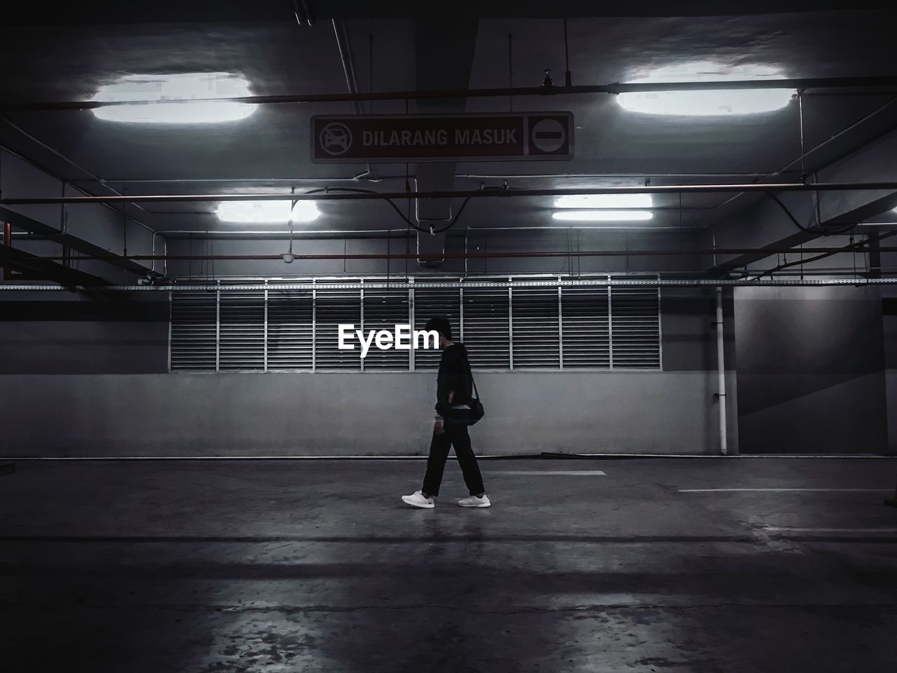 Rear view of man standing on illuminated subway