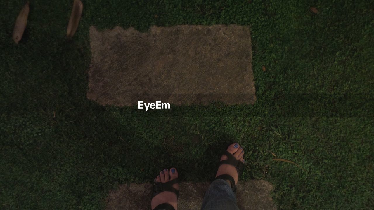 LOW SECTION OF PERSON STANDING ON TILED FLOOR