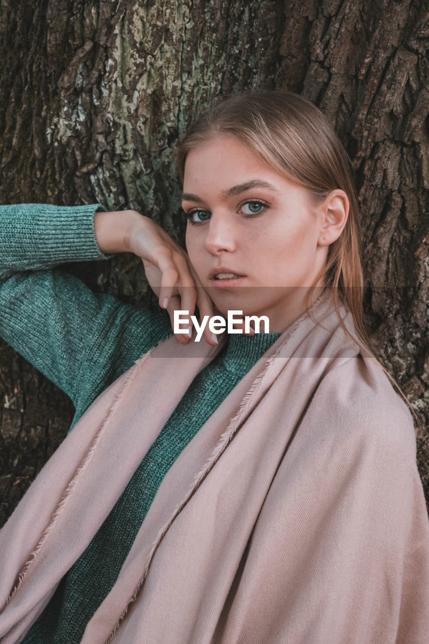 PORTRAIT OF BEAUTIFUL YOUNG WOMAN WITH TREE