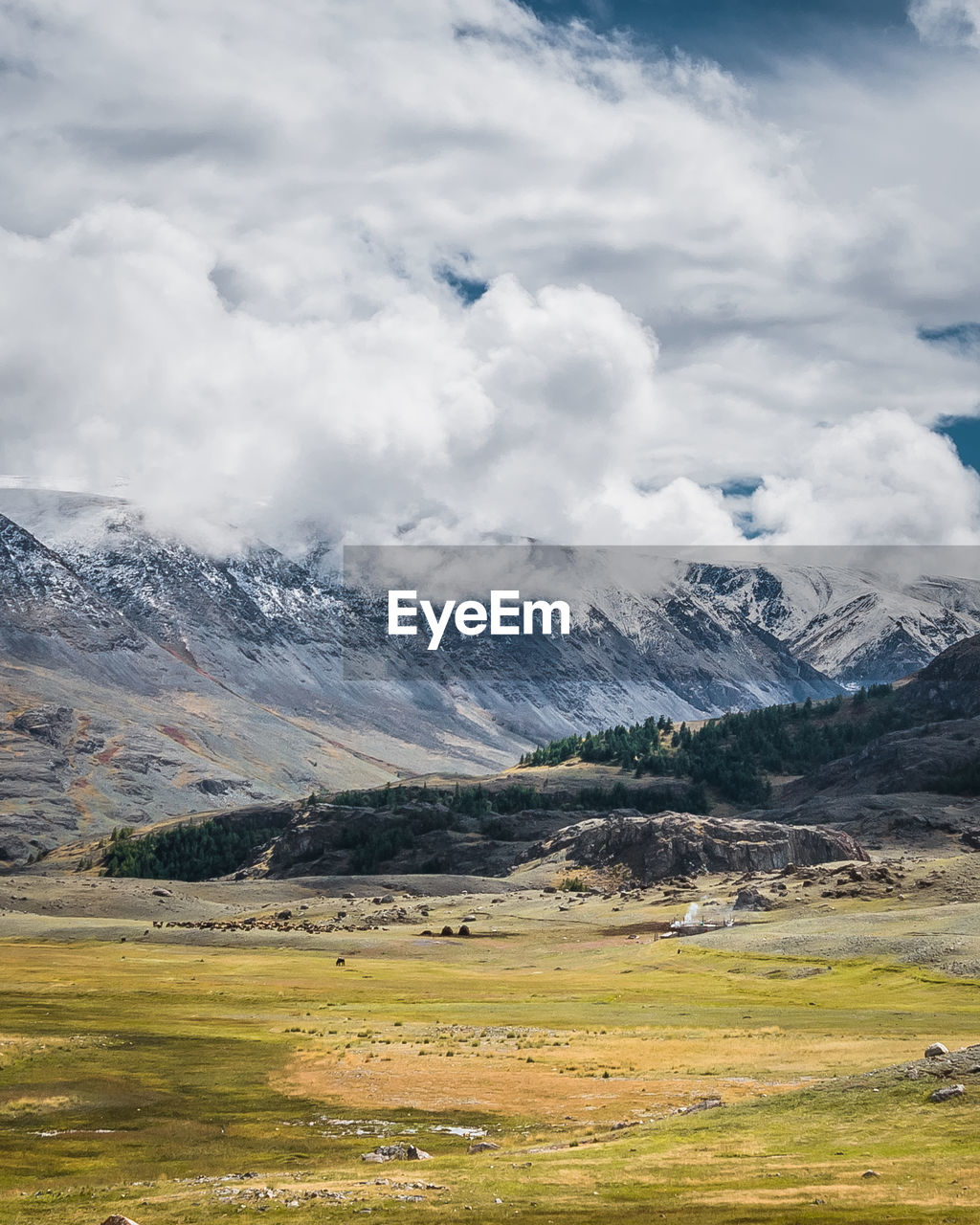 Scenic view of snowcapped mountains against cloudy sky