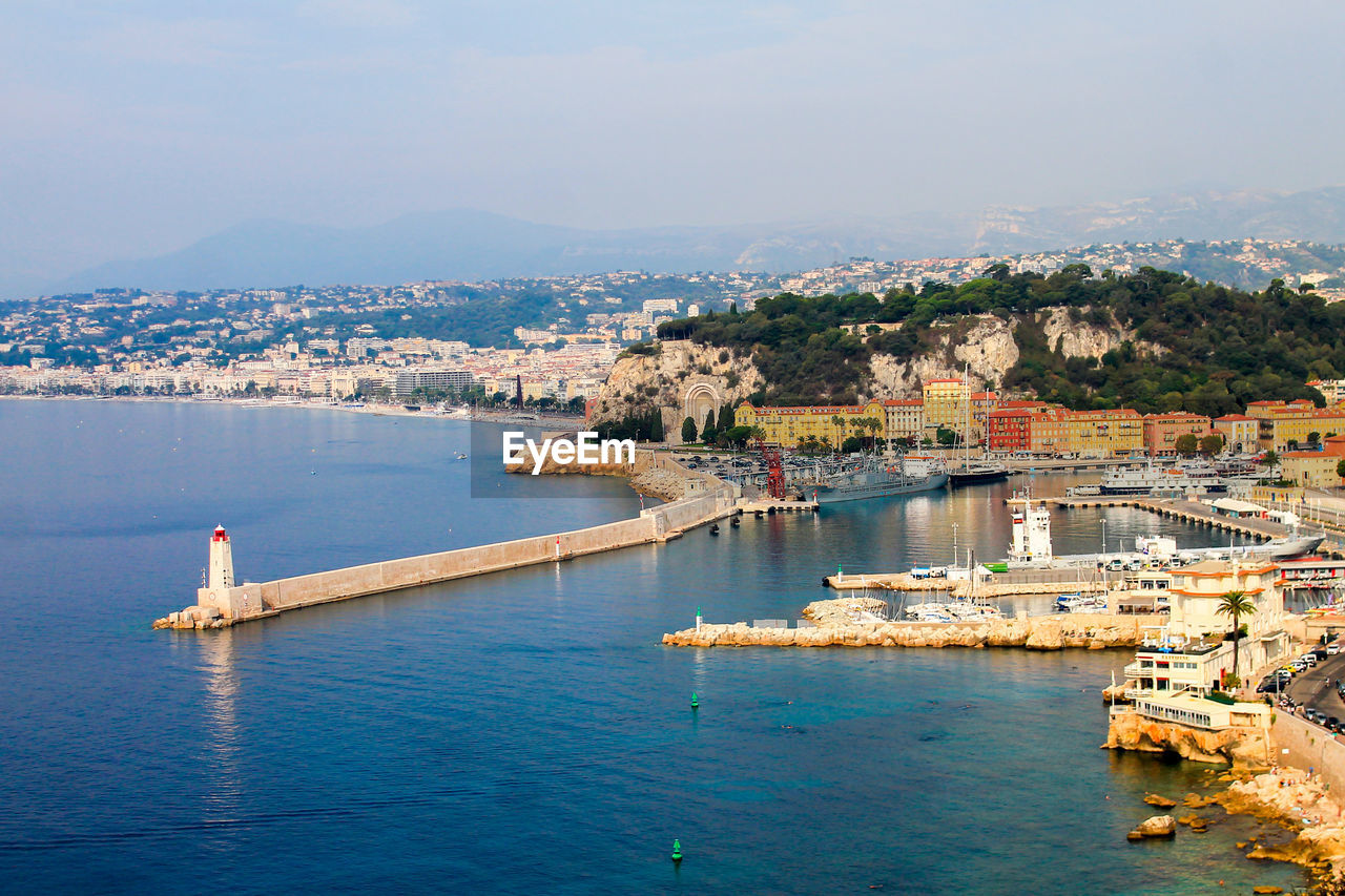 Scenic view of sea and cityscape against sky