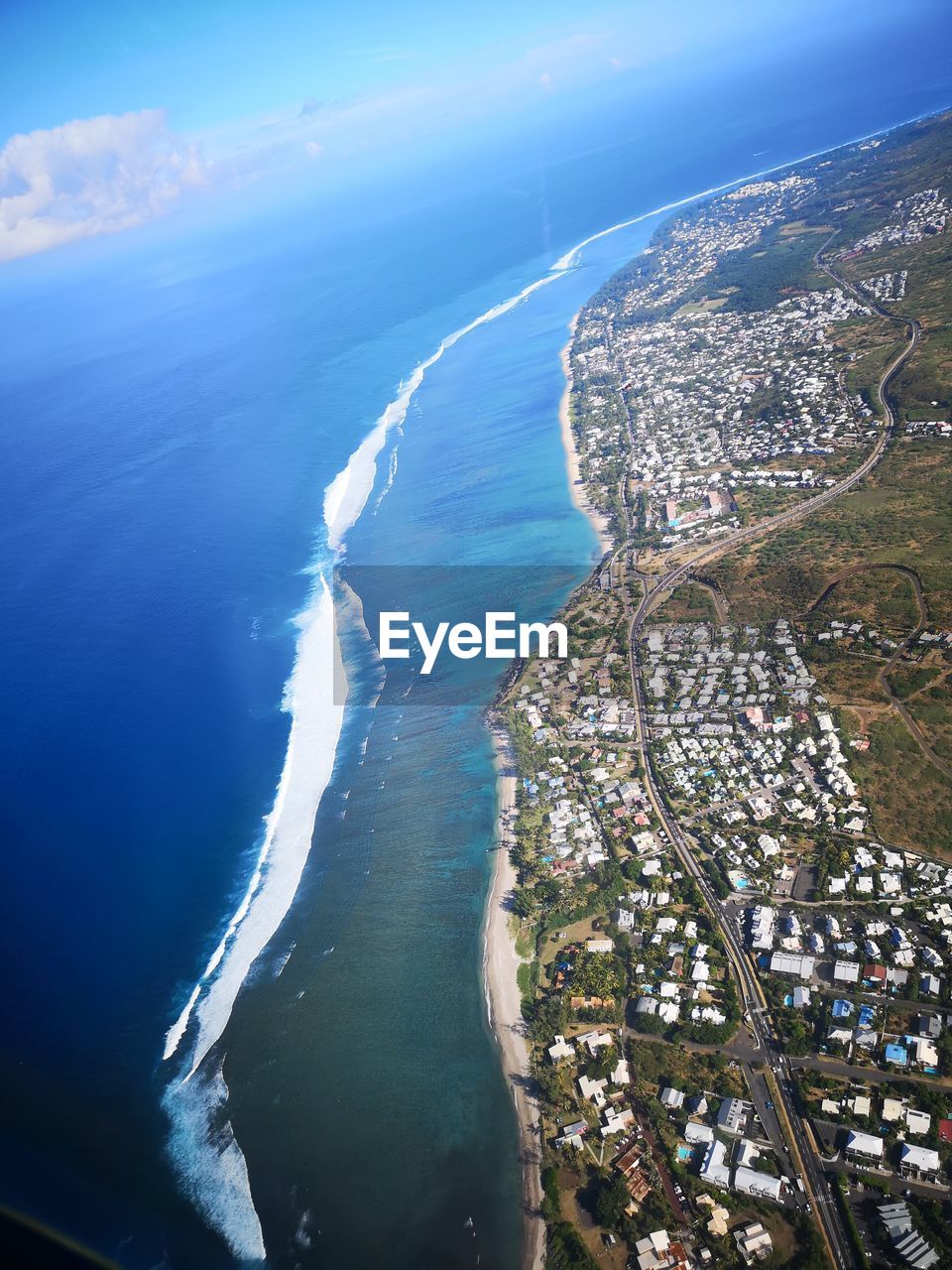 Aerial view of city by sea against sky