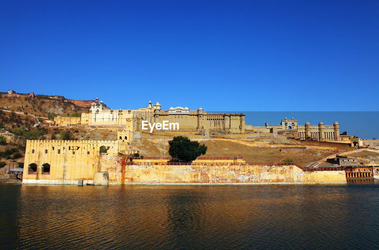 View of maota lake by amber fort against clear blue sky