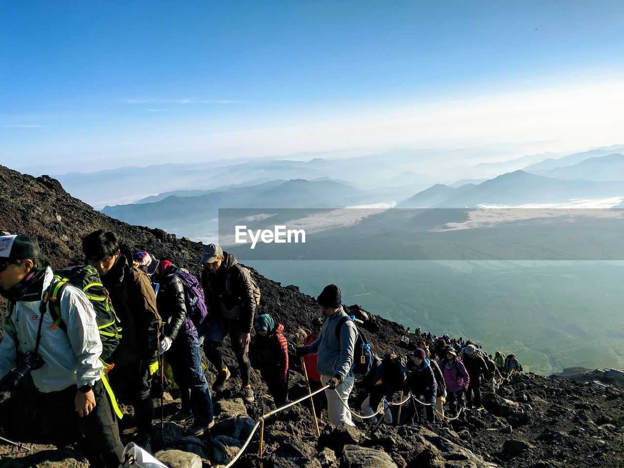 PANORAMIC SHOT OF CROWD ON MOUNTAIN AGAINST SKY