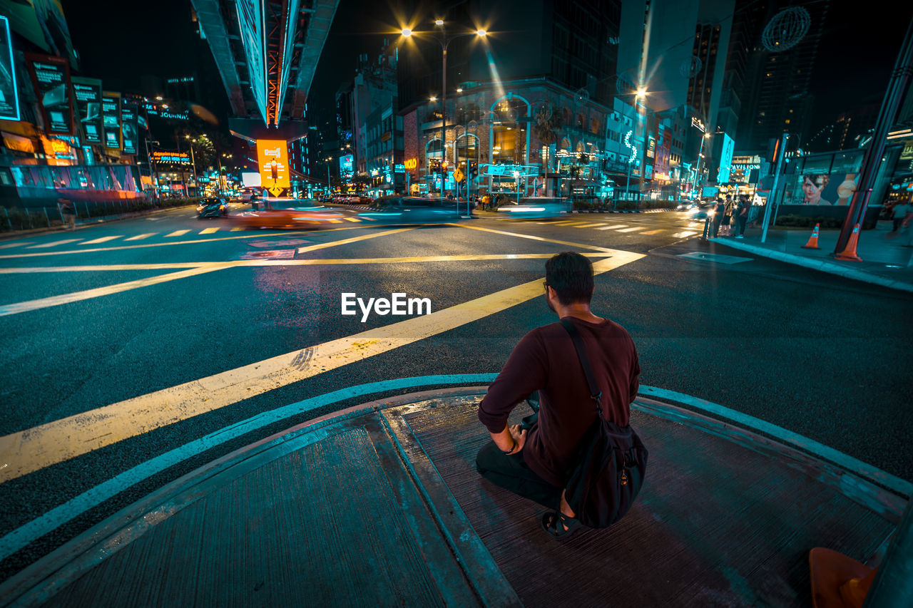 Rear view of man on street in city at night