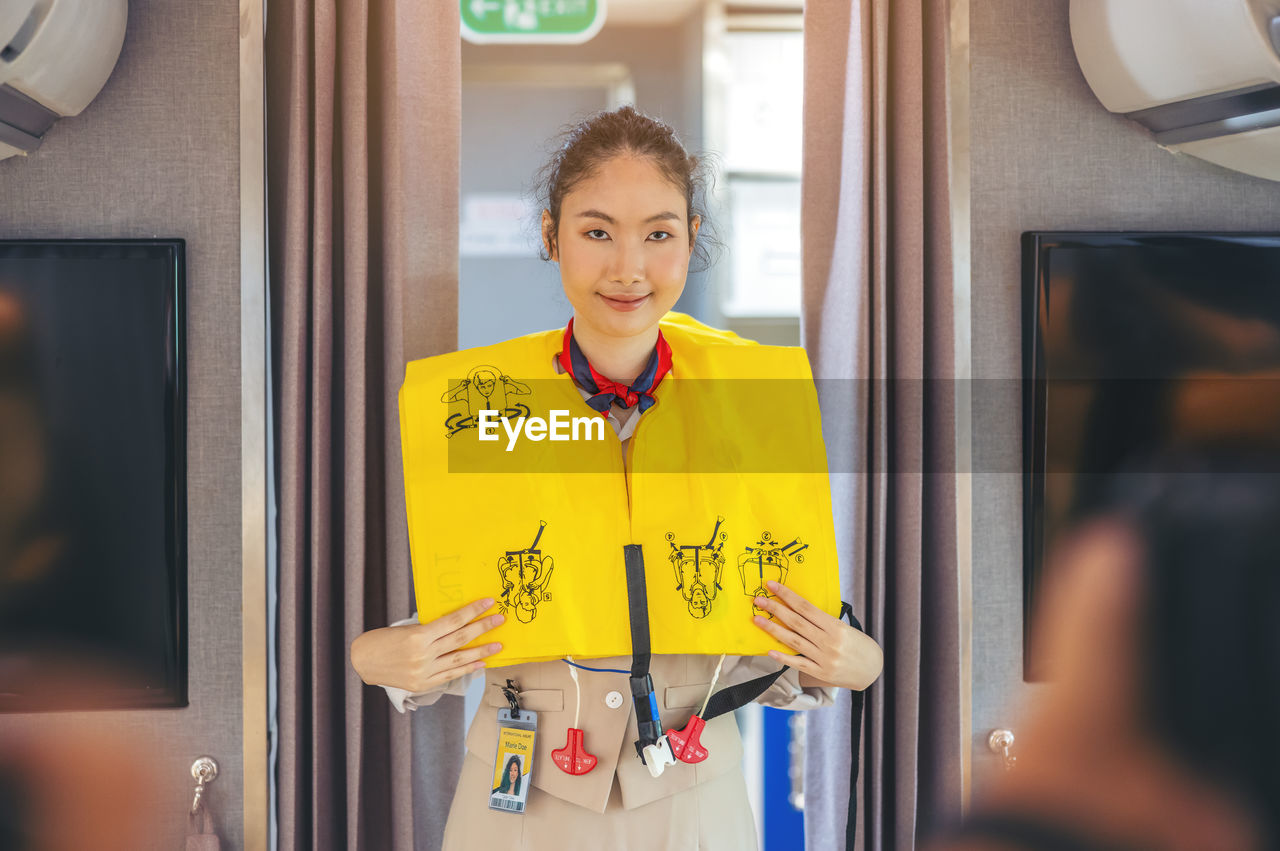 Prior to the flight's takeoff, an air hostess presents safety procedures to passengers.