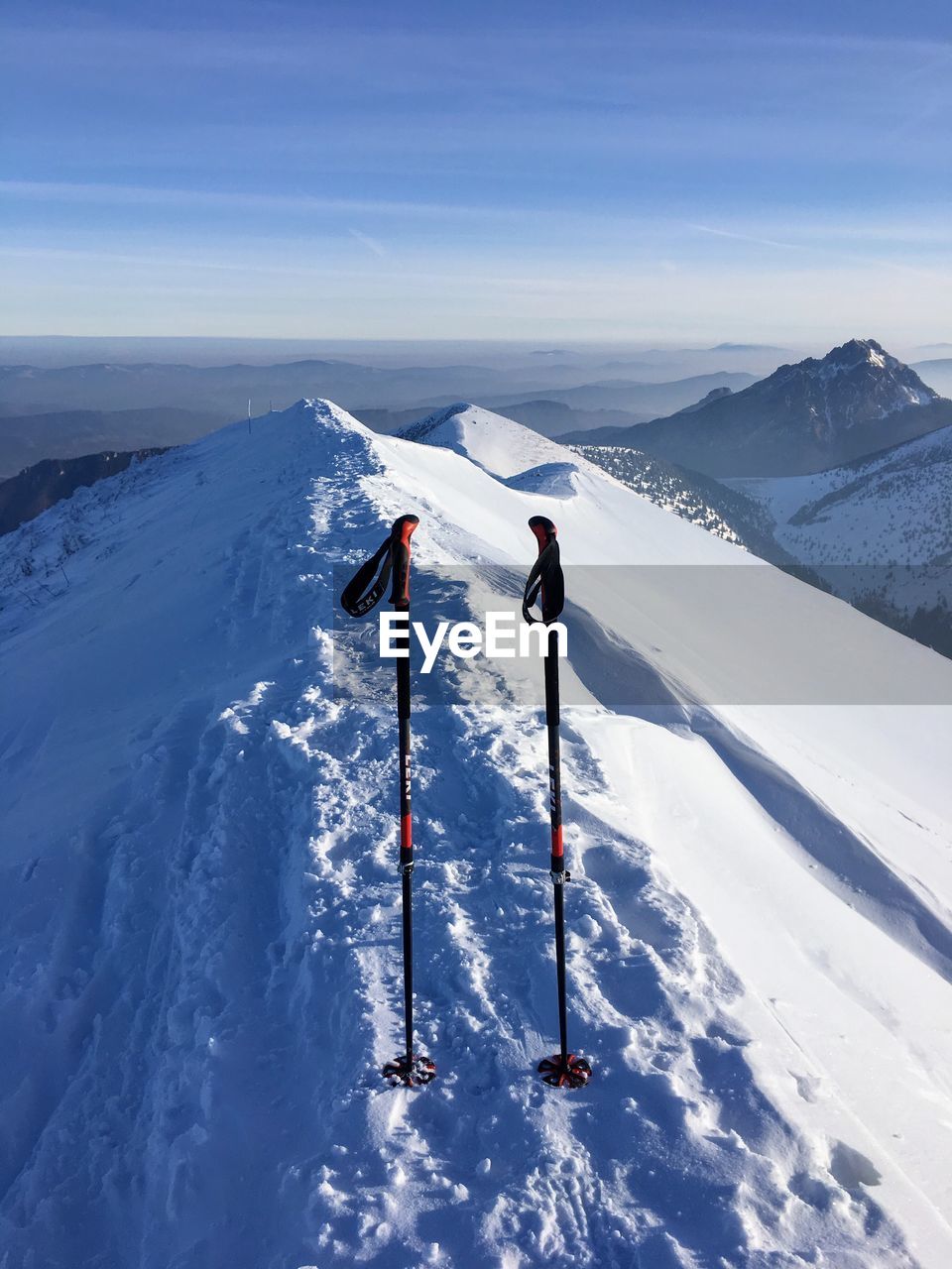 PEOPLE SKIING ON SNOW COVERED MOUNTAIN AGAINST SKY