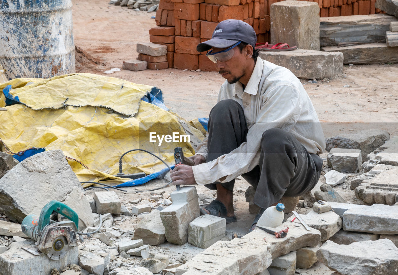 SIDE VIEW OF A MAN WORKING AT CONSTRUCTION SITE