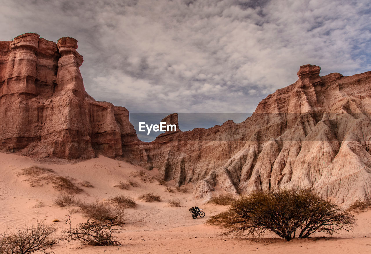 Rock formations on landscape against cloudy sky