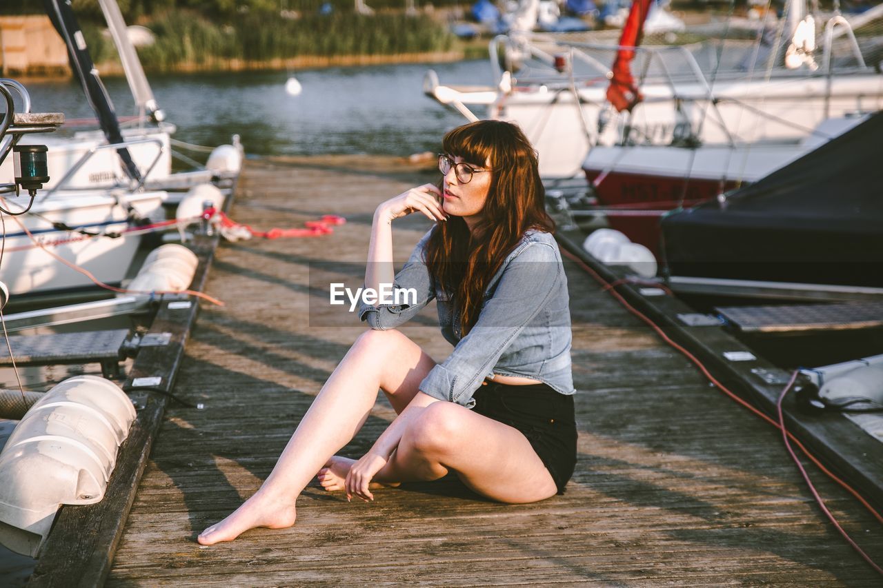 YOUNG WOMAN SITTING IN BOAT