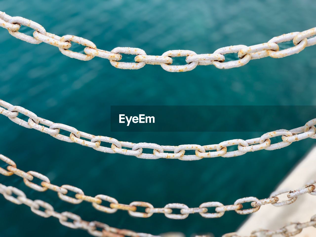 Close-up of rusty chain against sea