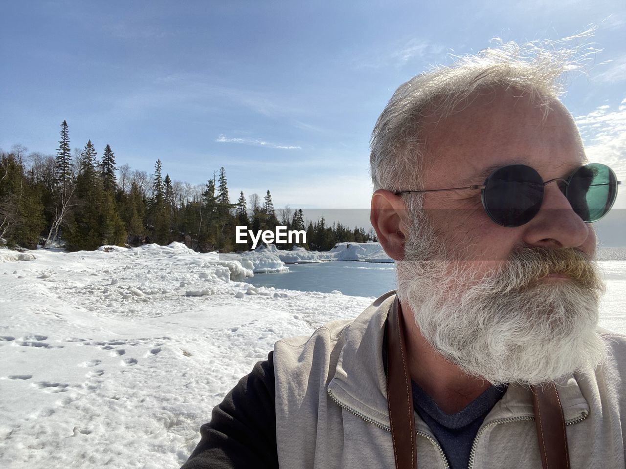 Portrait of man wearing sunglasses against sky during winter