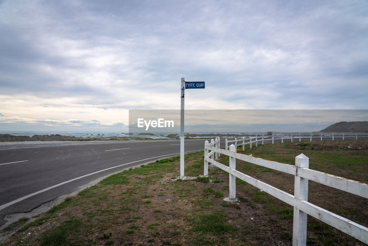 ROAD SIGN ON LAND AGAINST THE SKY