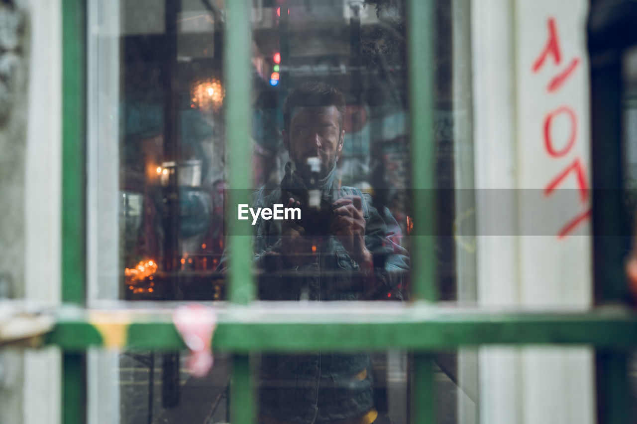 Reflection of man on glass window