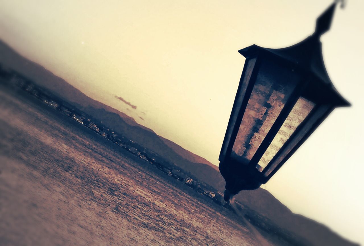 Street light in front of lake against sky