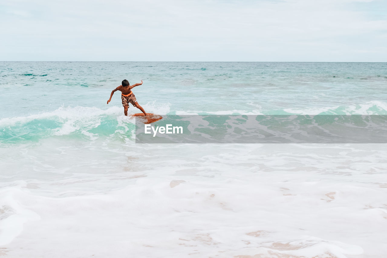 MAN SURFING IN SEA