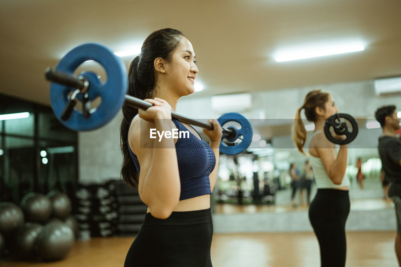 side view of young woman exercising in gym