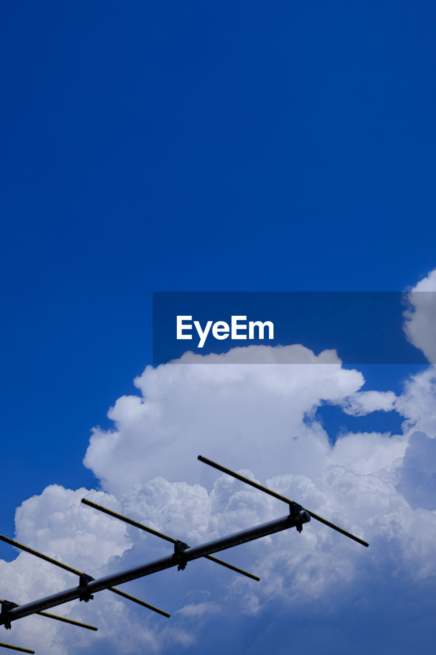 LOW ANGLE VIEW OF WIND TURBINES AGAINST BLUE SKY