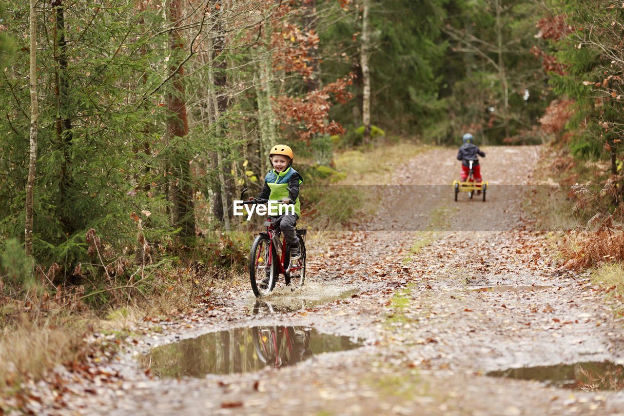 Boy cycling through forest