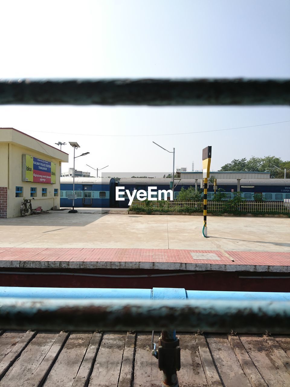 RAILROAD TRACKS BY PLATFORM AGAINST CLEAR SKY