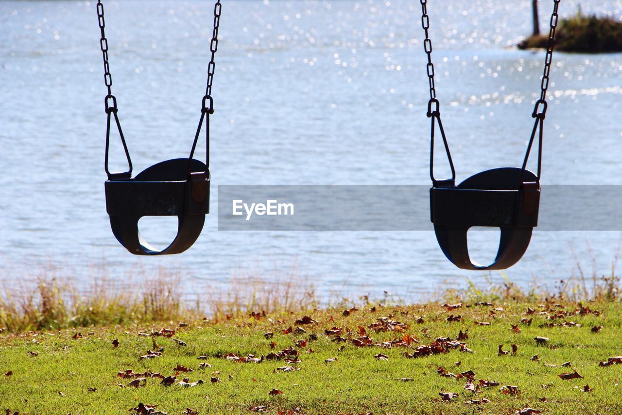 Swings hanging against lake