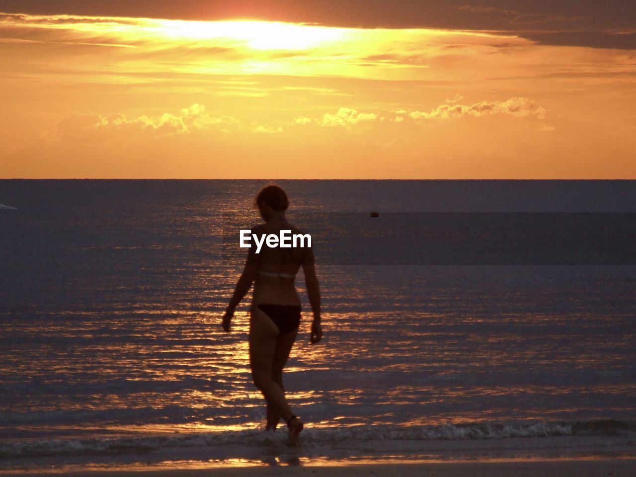 FULL LENGTH OF SILHOUETTE MAN ON BEACH AGAINST SKY AT SUNSET