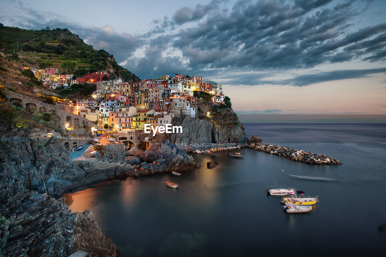 Aerial view of townscape by sea against sky