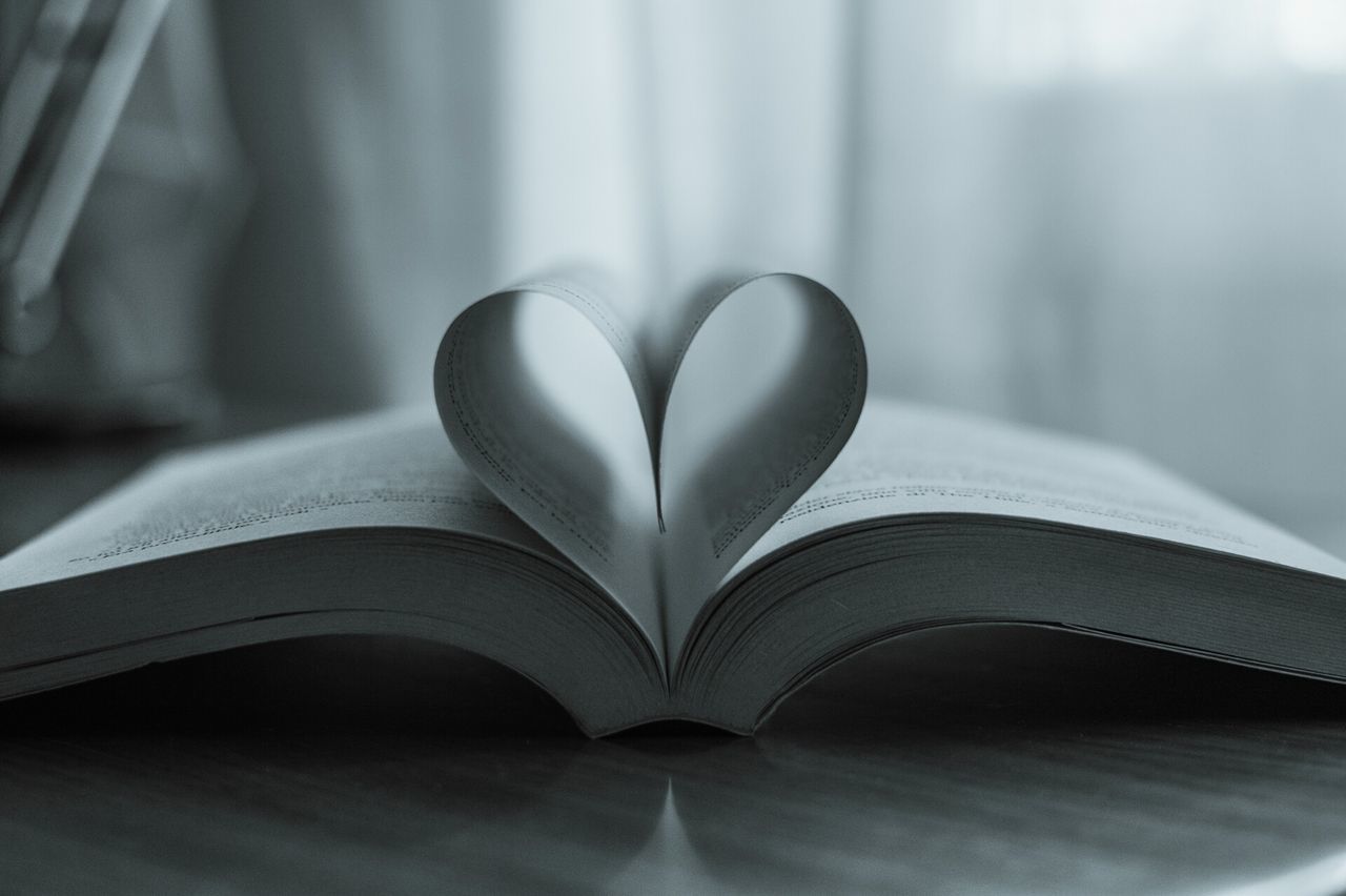 Close-up of heart shape made with papers on book