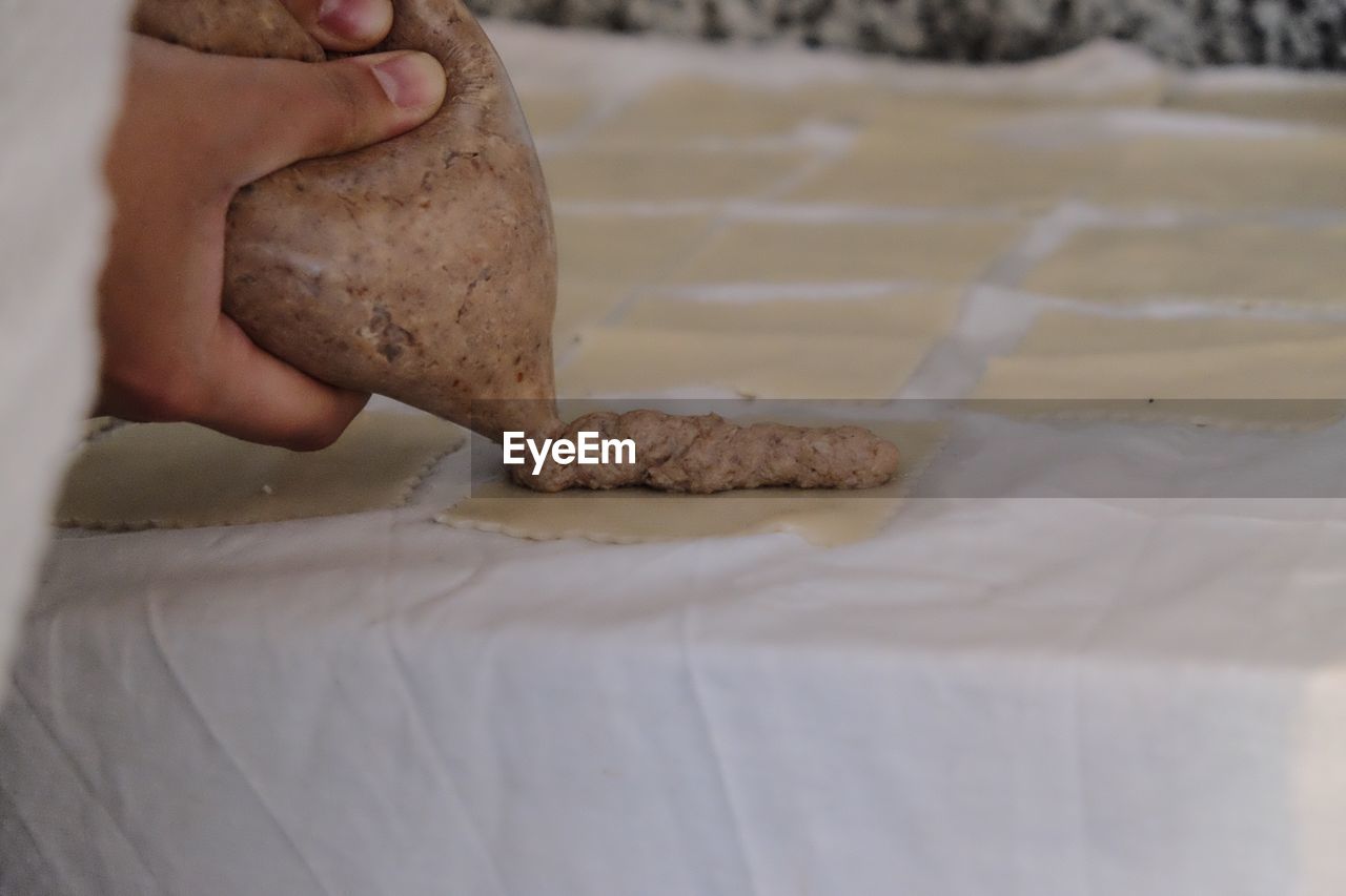 CLOSE-UP OF MAN PREPARING BREAD