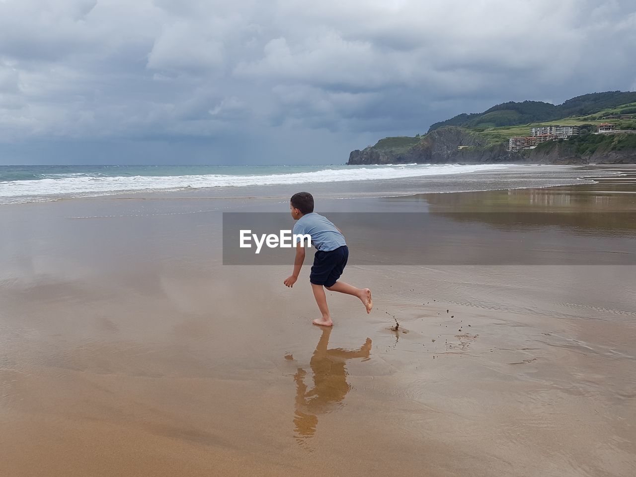 Rear view of child beach against sky