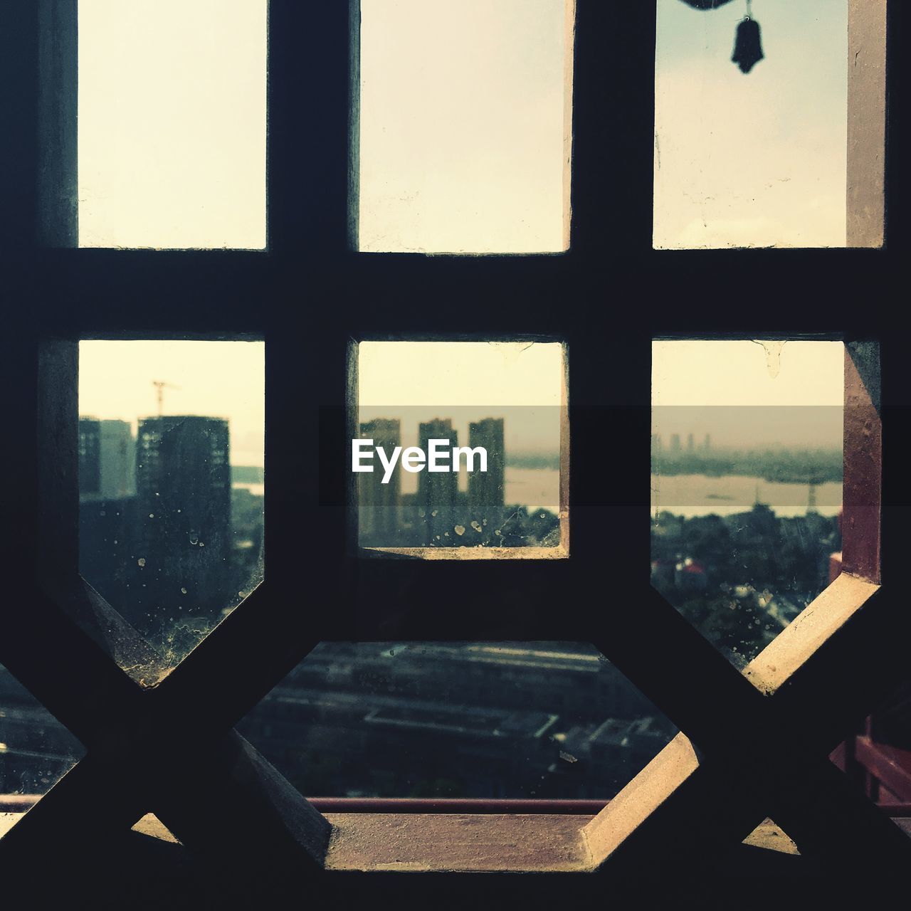 Close-up of cityscape against sky seen through window