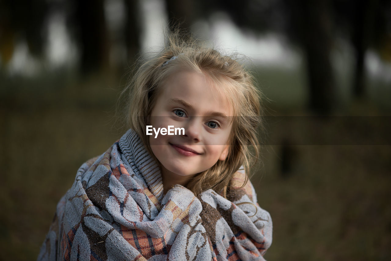 Close-up of cute girl wrapped in blanket