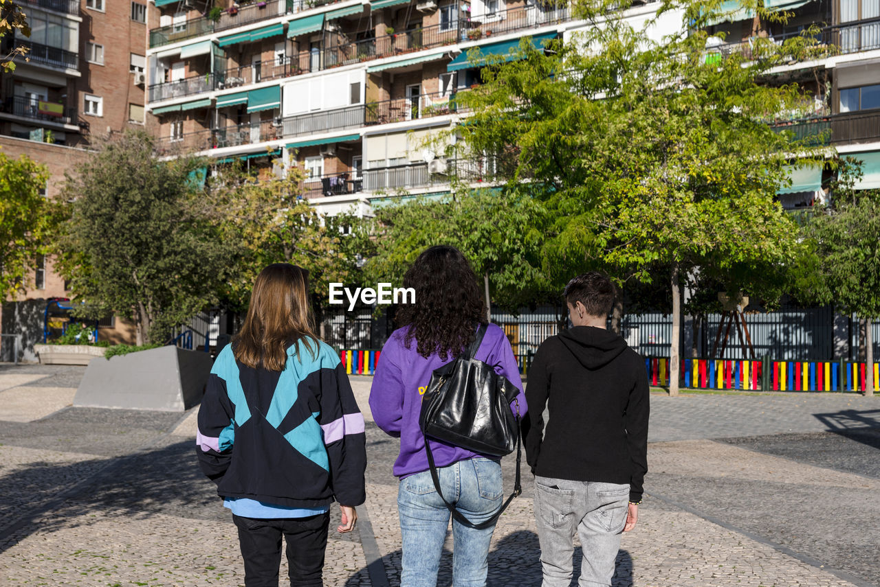 Young diverse friends walking outdoors on the street.