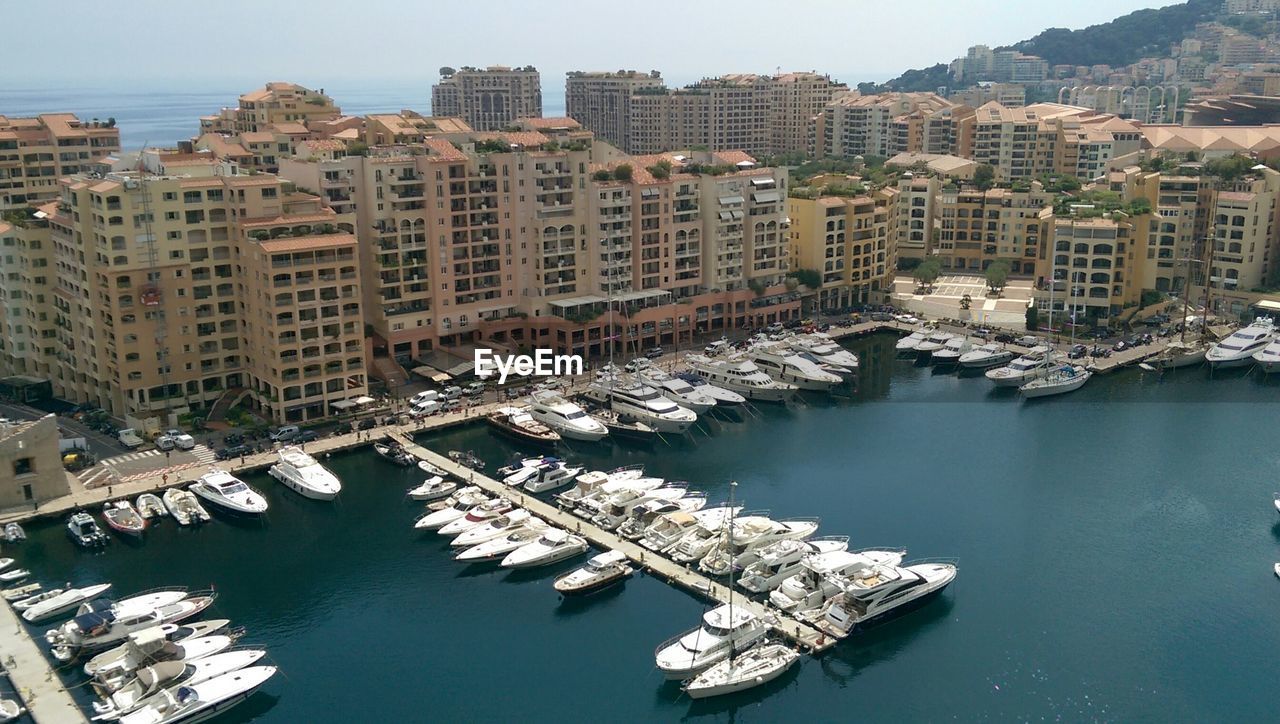 Boats moored in sea with buildings behind