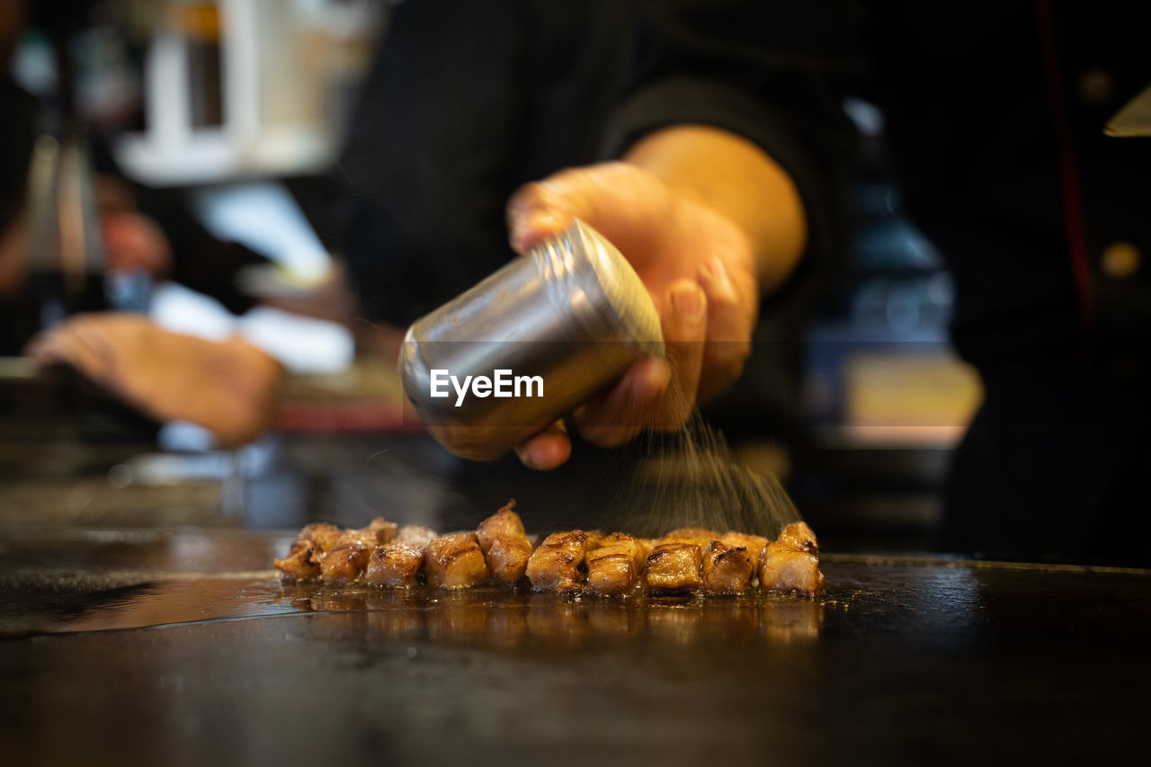 food and drink, food, occupation, freshness, one person, indoors, business, hand, adult, business finance and industry, working, small business, selective focus, food and drink establishment, food and drink industry, preparing food, pouring, men, kitchen, close-up, holding