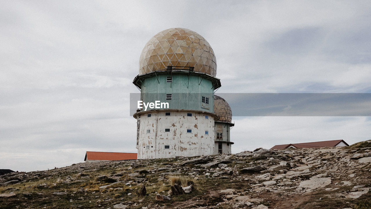 Low angle view of lighthouse on building against sky