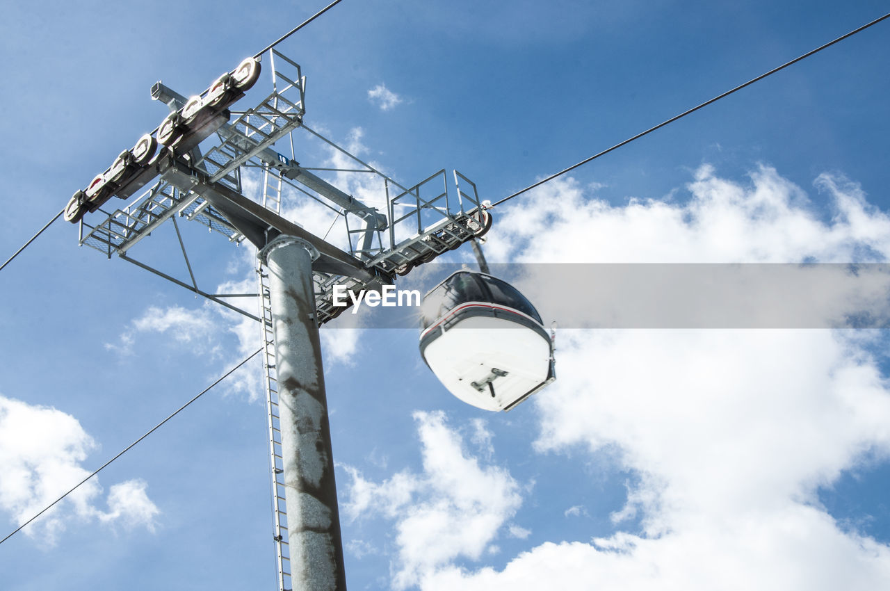 Low angle view of overhead cable car against sky