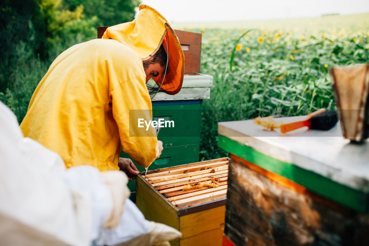 Beekeepers standing by containers