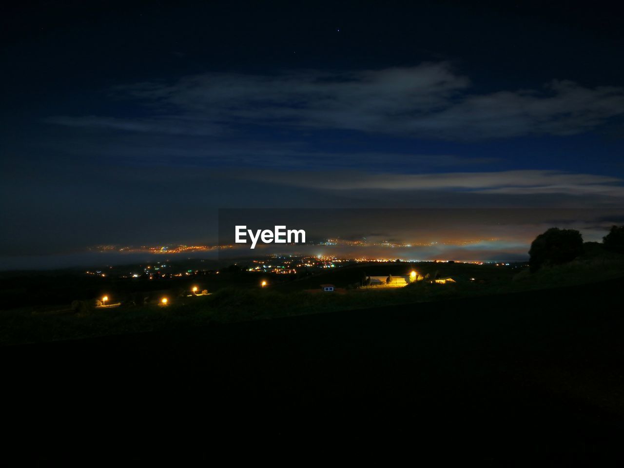 ILLUMINATED CITY AGAINST SKY