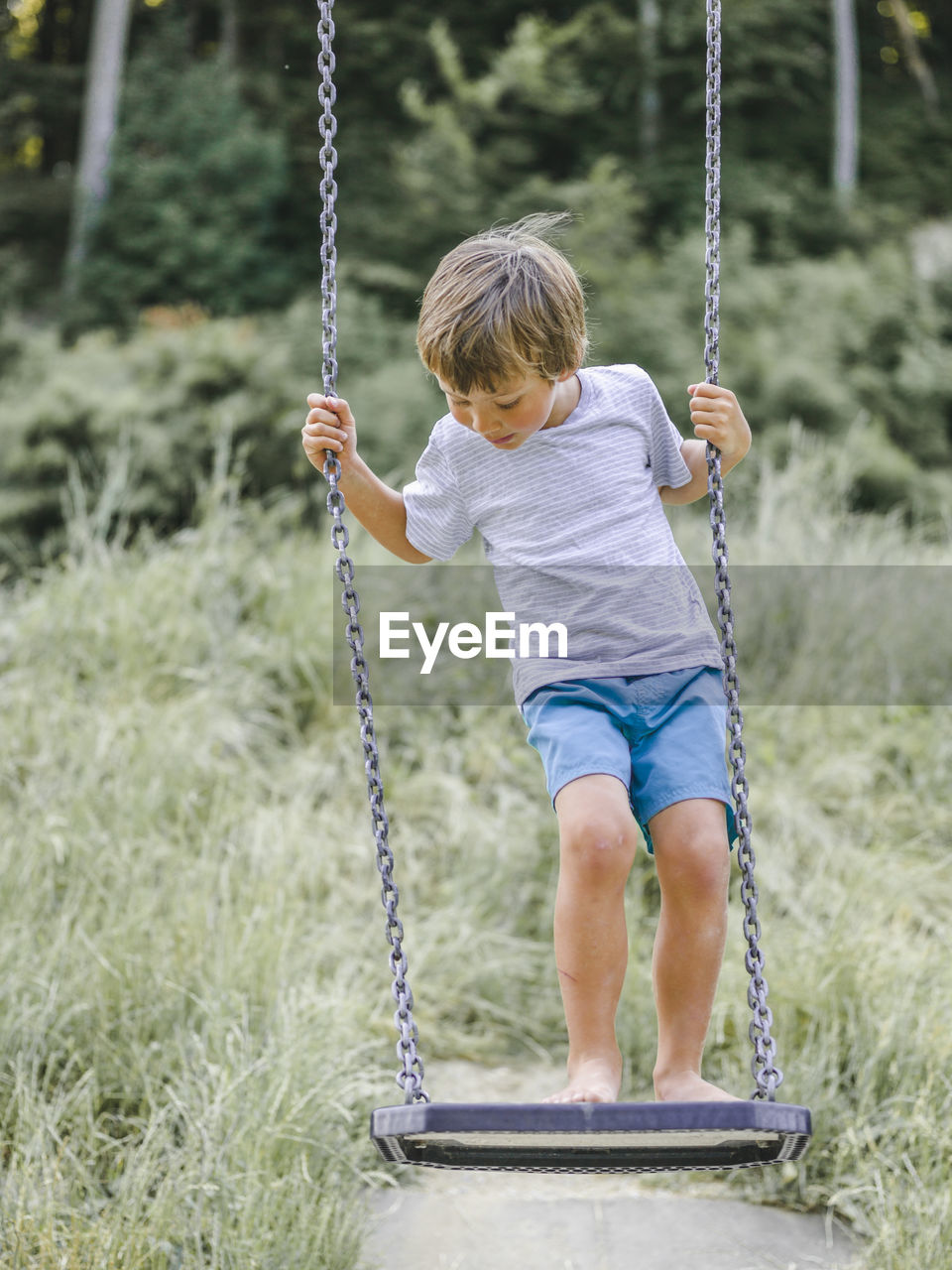 Full length of boy on swing at playground