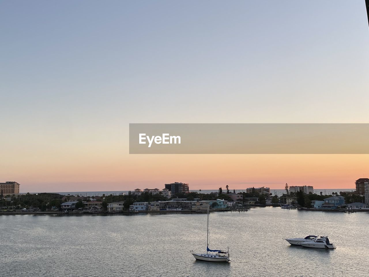 BOATS IN SEA AGAINST BUILDINGS IN CITY