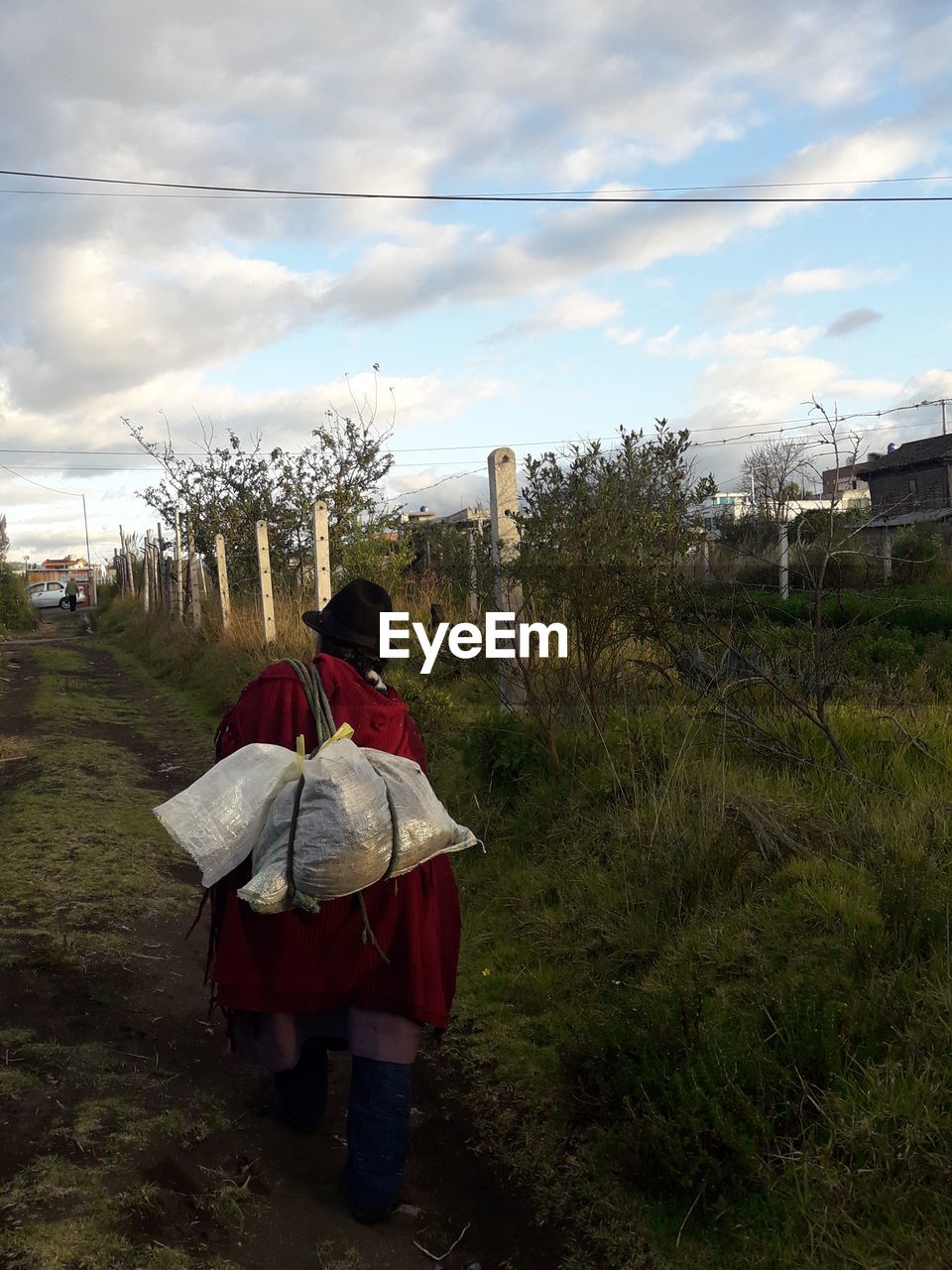 REAR VIEW OF WOMAN WITH UMBRELLA WALKING ON FIELD