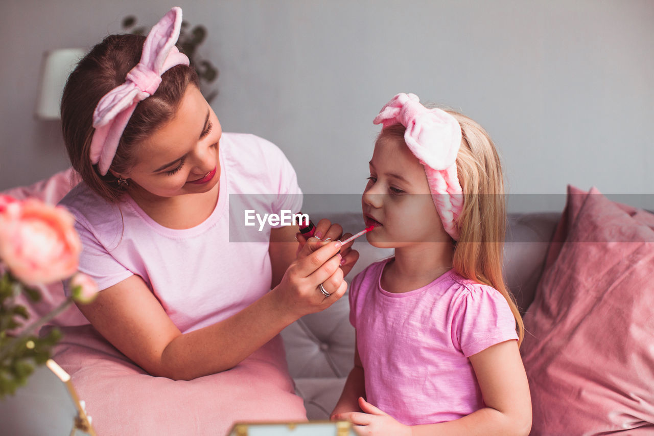 High angle view of girl holding pink while sitting at home