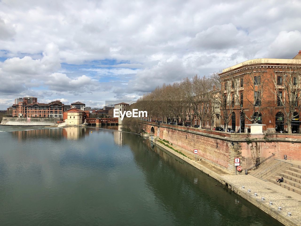 Panoramic shot of river by town against sky