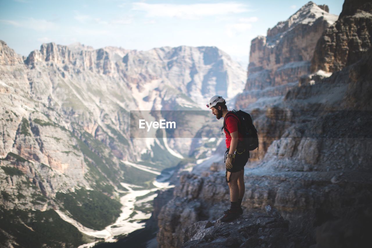 Side view of young man standing on mountain