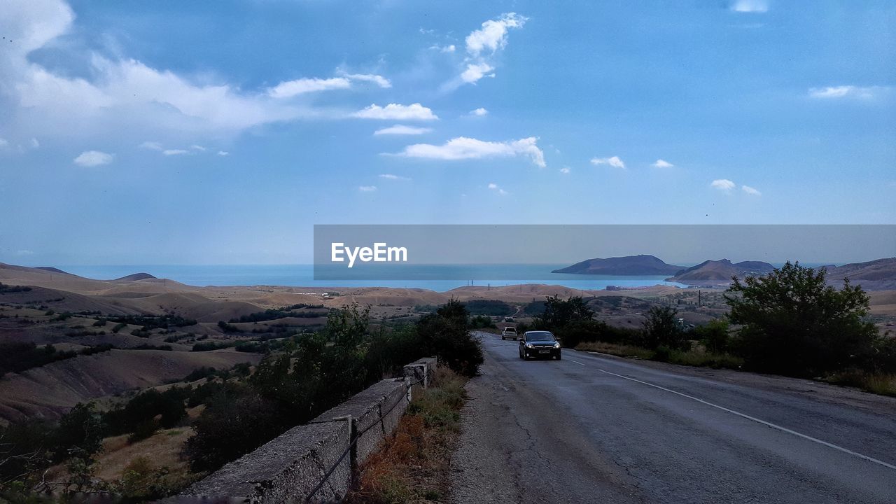 CAR ON ROAD AGAINST SKY