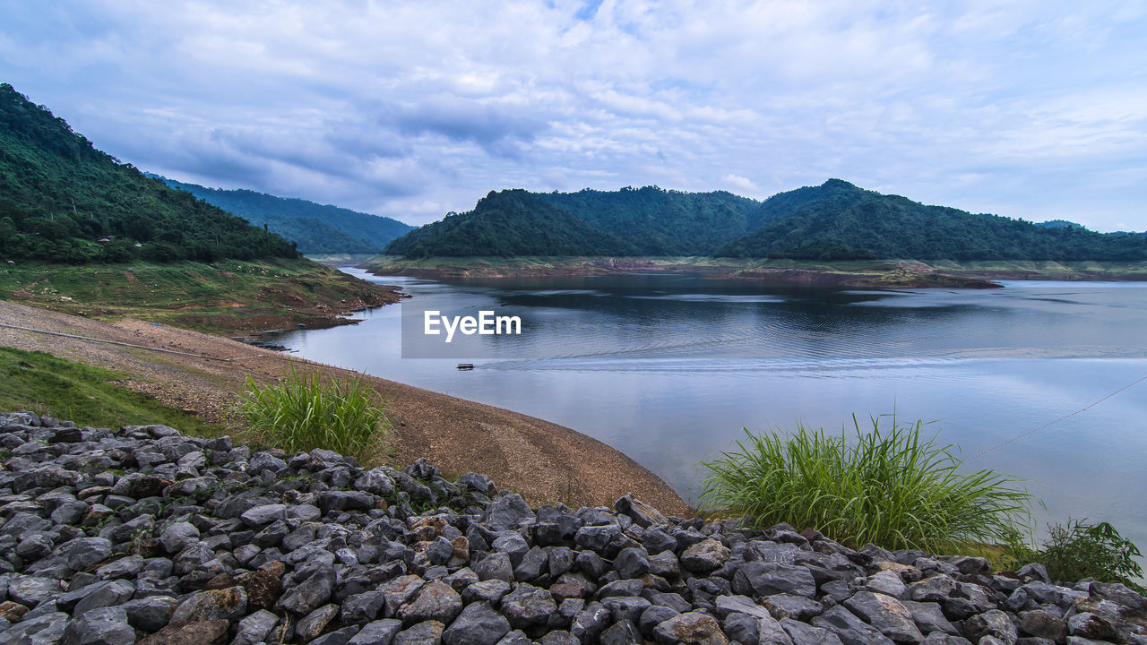 SCENIC VIEW OF LAKE BY MOUNTAIN AGAINST SKY