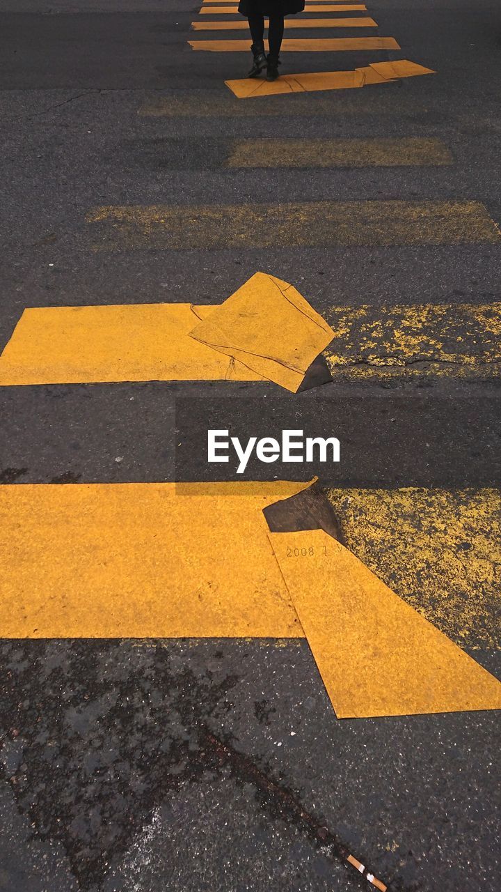 High angle view of yellow crossing sign on road